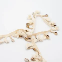 Frange à pompons et coquillages