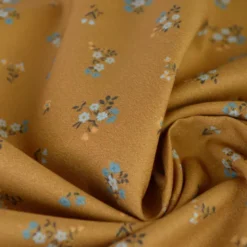 Popeline de coton Bisou motif fleurs bleues fond Ocre