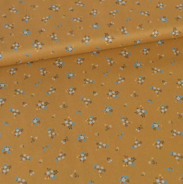 Popeline de coton Bisou motif fleurs bleues fond Ocre