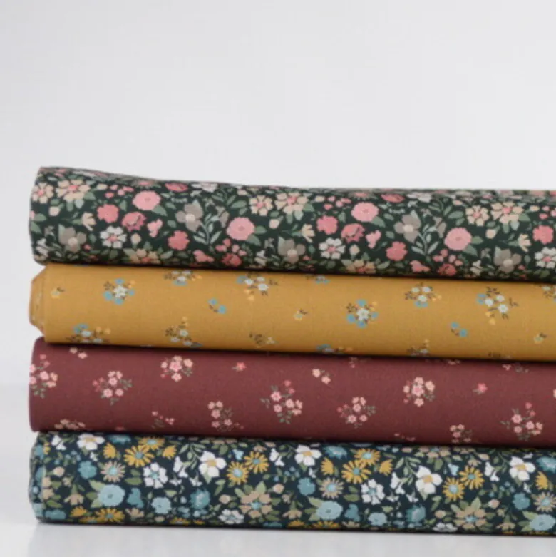 Popeline de coton Bisou motif fleurs bleues fond Ocre