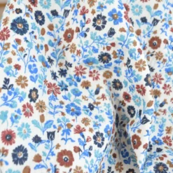 Tissu double gaze de coton Aryada fleurs bleues fond écru