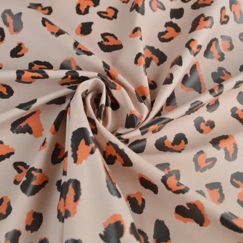 Tissu imperméable Saian type ciré de pluie motif léopard coeurs fond galet