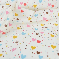 Tissu imperméable Tiamo type ciré de pluie motif coeurs bleus et roses