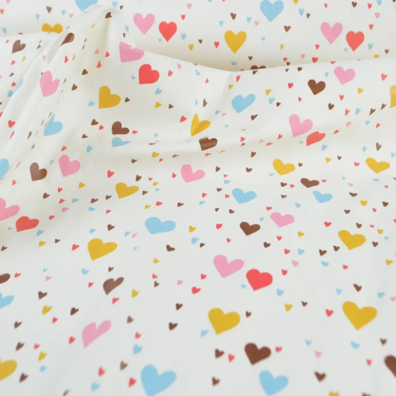 Tissu imperméable Tiamo type ciré de pluie motif coeurs bleus et roses