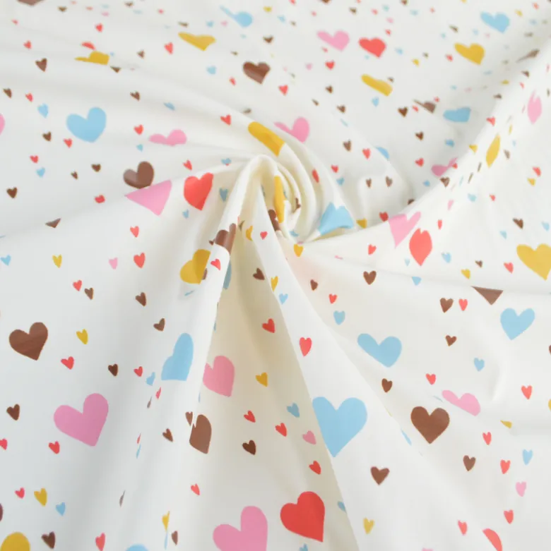 Tissu imperméable Tiamo type ciré de pluie motif coeurs bleus et roses