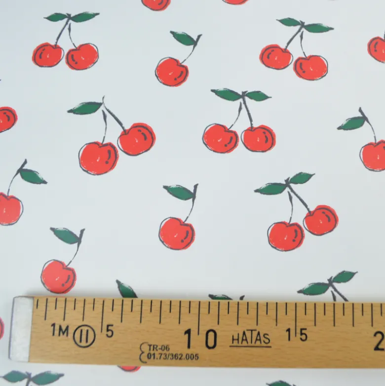 Tissu imperméable type ciré motif cerises fond blanc