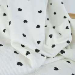 Tissu jersey côtelé motif coeurs Noirs fond blanc