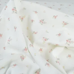 Tissu jersey côtelé motif fleurs roses fond blanc cassé