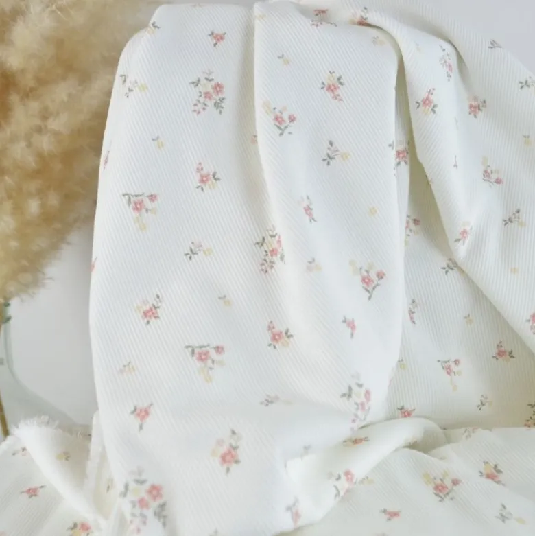 Tissu jersey côtelé motif fleurs roses fond blanc cassé