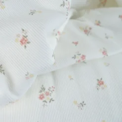 Tissu jersey côtelé motif fleurs roses fond blanc cassé