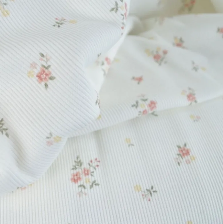 Tissu jersey côtelé motif fleurs roses fond blanc cassé