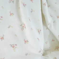 Tissu jersey côtelé motif fleurs roses fond blanc cassé