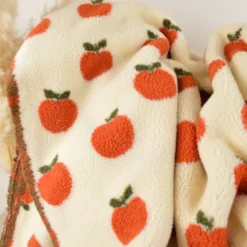 Tissu Sherpa motif pommes orangées fond écru