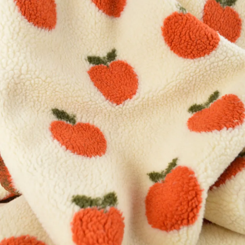 Tissu Sherpa motif pommes orangées fond écru