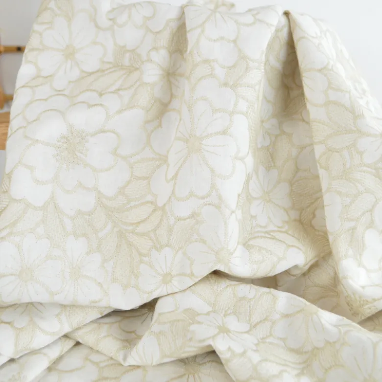 Tissu voile de coton brodé beige motif fleurs fond sable