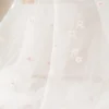 Tulle brodé blanc brodé de fleurs roses