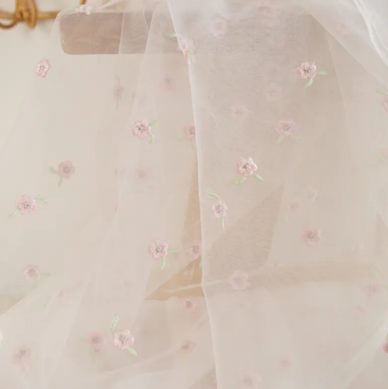 Tulle brodé blanc brodé de fleurs roses