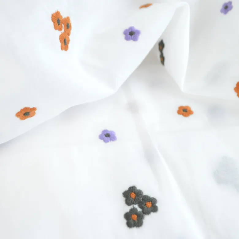 Voile de coton brodé de petites fleurs camel fond blanc
